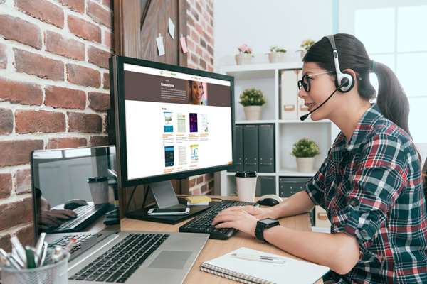 woman wearing a headset and on the computer